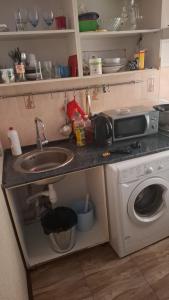 a small kitchen with a sink and a microwave at Махамбета in Atyrau