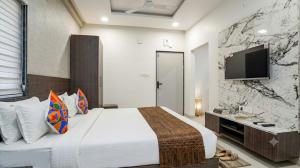 a bedroom with a large bed and a flat screen tv at homly hotel in Indore