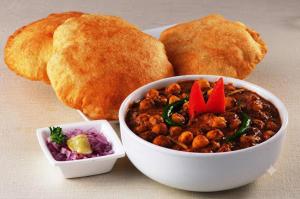 a plate of food with a bowl of chili and bread at homly hotel in Indore