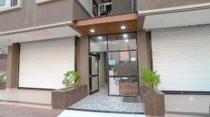 a building with two garage doors and two plants at homly hotel in Indore