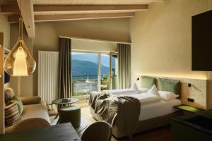 a living room with a bed and a large window at Hotel AUI in Maranza