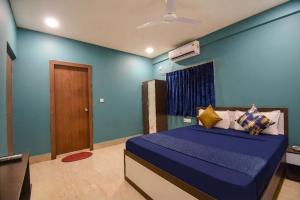a blue bedroom with a bed with a blue wall at FabHotels Calyra in Karīmnagar