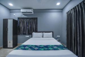 a bedroom with a bed and a window at FabHotels Calyra in Karīmnagar