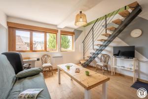 a living room with a couch and a table at Le clos bambou in Loueuse