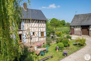 an old house with a garden in front of it at Le clos bambou in Loueuse