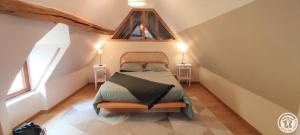 a small bedroom with a bed in a attic at Le clos bambou in Loueuse