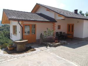 a small white house with a table in front of it at Prima Apartment in Podbočje