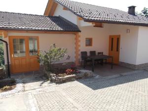 a house with a patio with a table in front of it at Prima Apartment in Podbočje