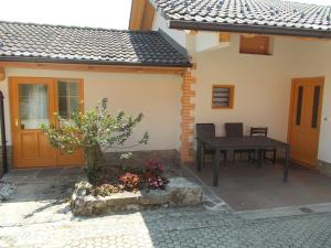 a patio of a house with a table and chairs at Prima Apartment in Podbočje
