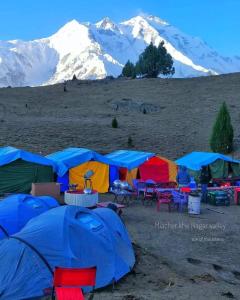 a group of tents with mountains in the background at Hello Rakaposhi Camping Site in Gilgit