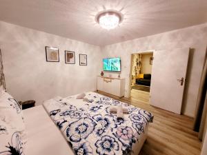 a bedroom with a bed with a blue and white comforter at Modernes Wohlfühl-Apartment mit Stil in Mülheim an der Ruhr +15 photos