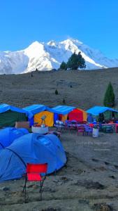 a group of tents with mountains in the background at Hello Rakaposhi Camping Site in Gilgit +4 photos