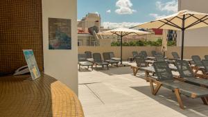 a patio with chairs and tables and umbrellas on a roof at VIP Executive Zurique Hotel in Lisbon