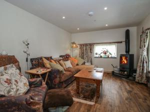 a living room with a couch and a wood stove at Buzzards Breg in Builth Wells