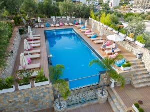 an overhead view of a swimming pool with chairs and umbrellas at Moncler Residence in Ksamil