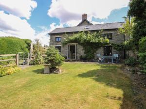 an old stone house with a yard in front of it at Buzzards Breg in Builth Wells