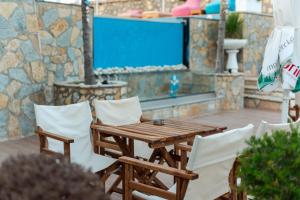 a wooden table and chairs on a patio at Moncler Residence in Ksamil