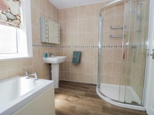 a bathroom with a shower and a sink and a tub at Roma in Rhos-on-Sea +47 photos