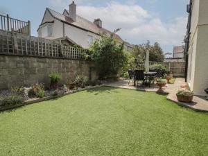 a garden with a lawn in front of a house at Roma in Rhos-on-Sea