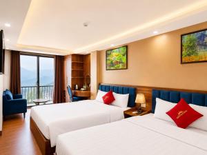 a hotel room with two beds and a balcony at Liberty Sapa Hotel in Sapa