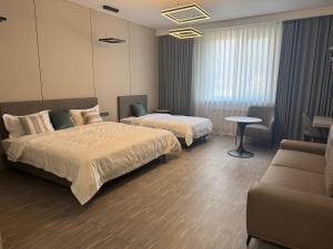 a hotel room with two beds and a couch at Wind Rose in Almaty