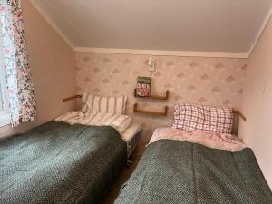 a bedroom with two beds and a window at Cozy small house with amazing view in Hennes