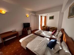 a hotel room with two beds and a couch at Hotel Atlantis in Tulcea