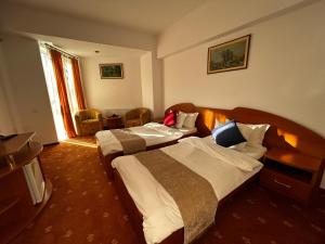 a hotel room with two beds and a television at Hotel Atlantis in Tulcea