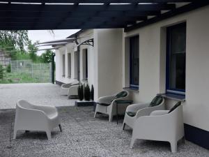 Eine Reihe Stühle steht an der Seite eines Gebäudes. in der Unterkunft Boutique-Stay in Eberswalde-Finow