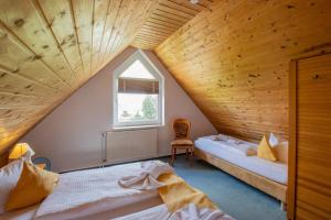 a attic bedroom with two beds and a window at Hotel garni Zwickau-Mosel in Mülsen