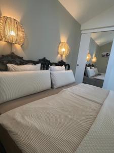 two beds in a bedroom with two lamps on the wall at Finca Malata in Turís