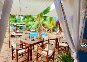 a patio with a table and chairs and a pool at Ocean Breeze Boutique Hotel in Nungwi