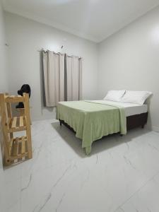 a bedroom with a bed with a green blanket and a ladder at Xodó de Casa, Paracuru in Paracuru +16 photos