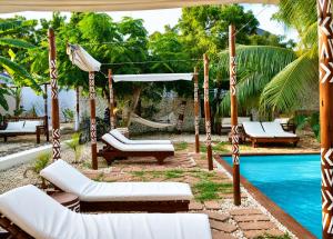 a patio with a swing and a pool at Ocean Breeze Boutique Hotel in Nungwi +48 photos