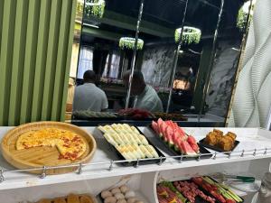 a buffet with food on a table in a restaurant at Bella Hotel Navoi in Karmana
