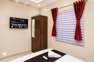 a bedroom with a bed and a window with red curtains at Hotel New Rajkamal in Aurangabad