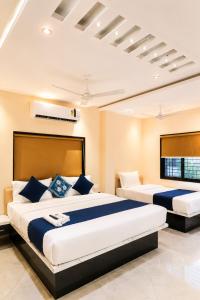 a bedroom with two beds in a room at Hotel New Rajkamal in Aurangabad