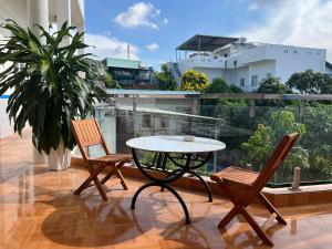 a patio with a table and two chairs on a balcony at VitaSea Mui Ne homestay & pool in Mui Ne