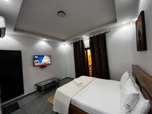 a bedroom with a bed and a flat screen tv at Sall Africa Tourisme in Mbour