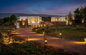 a house with lights on a driveway at night at Kadamb Bagh-A Luxury Nature Resort Sariska in Rāmsinghpura