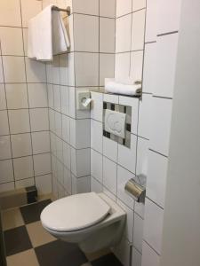 a bathroom with a toilet and towels on the wall at Apollo in Frankfurt