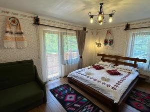 a bedroom with a large bed and a chandelier at Pensiunea Floare de Maramures in Vadu Izei