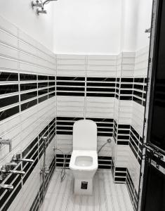 a bathroom with a toilet and black and white stripes at Hotel Vishnu Priya Ayodhya in Ayodhya