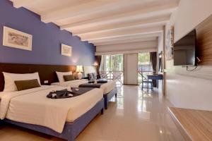 a hotel room with two beds and a flat screen tv at Natural Park Resort Pattaya in Jomtien Beach