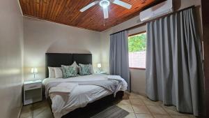 a bedroom with a bed with a ceiling fan at Fisherman's 6-Bedroom Family Home in St Lucia +10 photos