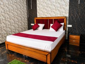 a bedroom with a bed with red and white pillows at Hotel Vishnu Priya Ayodhya in Ayodhya +16 photos