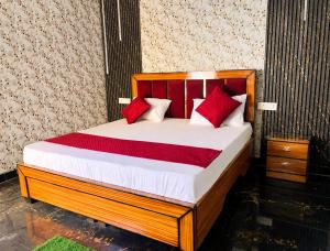 a bedroom with a wooden bed with red pillows at Hotel Vishnu Priya Ayodhya in Ayodhya
