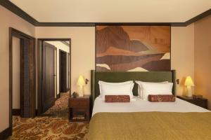 a bedroom with a bed with a large painting on the wall at Hotel Saint Roch in Courchevel