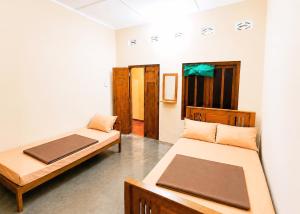 a room with two beds in a room at Yarl Retreat - Jaffna Town - Non-AC in Jaffna