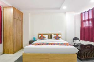 a bedroom with a large bed and a wooden cabinet at Hotel Shyam Villa - Govindpuri Metro in New Delhi +21 photos
